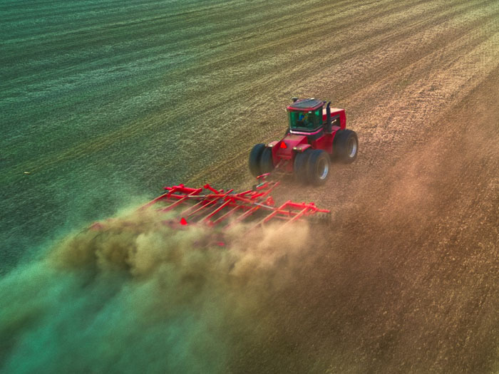Case tractor pulling an disk in a field
